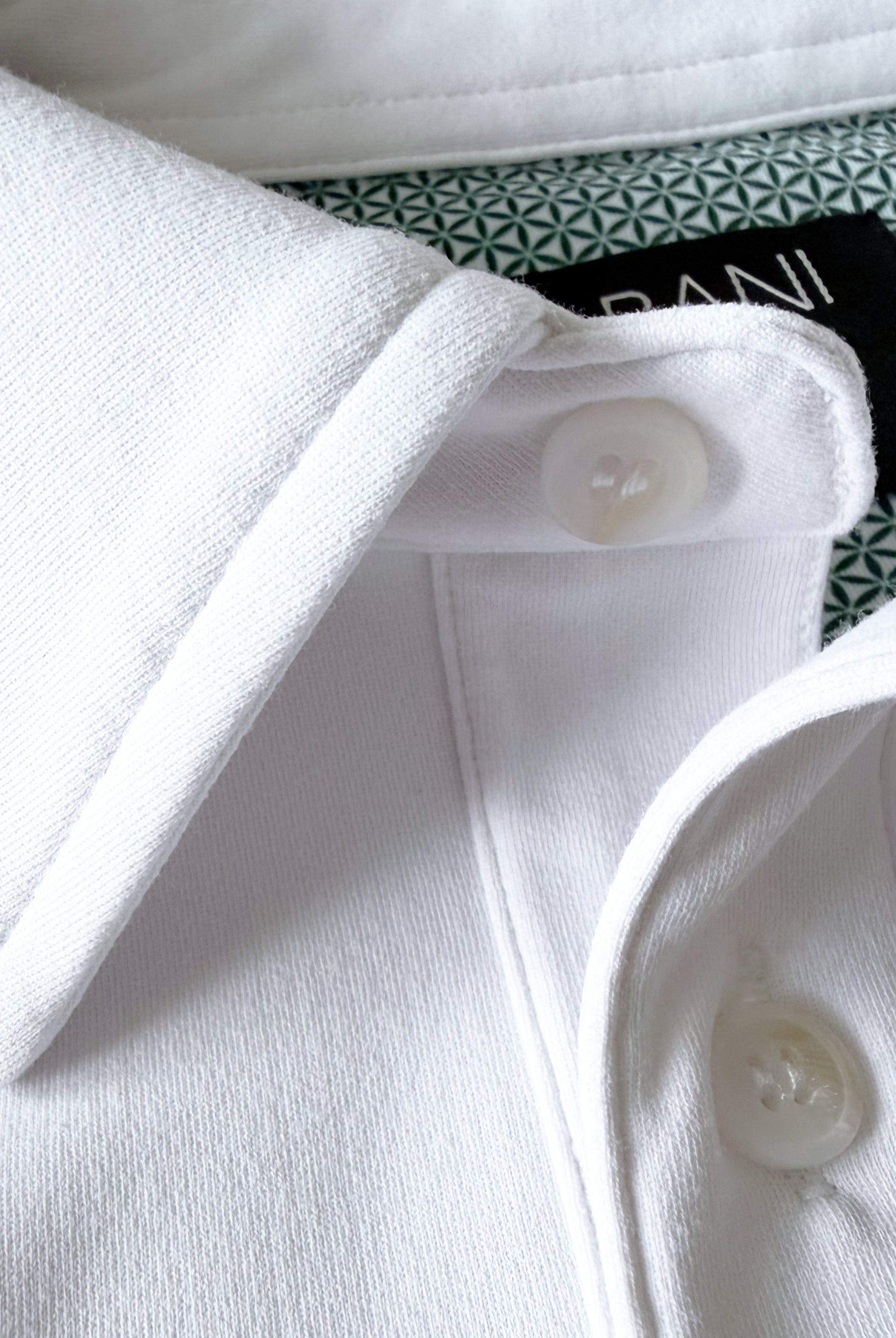 Close-up view of TARANIRVANA Porcelain white Polo shirt collar, highlighting the premium placket buttons, minimalist tailored collar, and high-performance SpiroTex™ fabric with quick-dry, moisture-wicking, odor-resistant, and UPF 50+ sun protection.