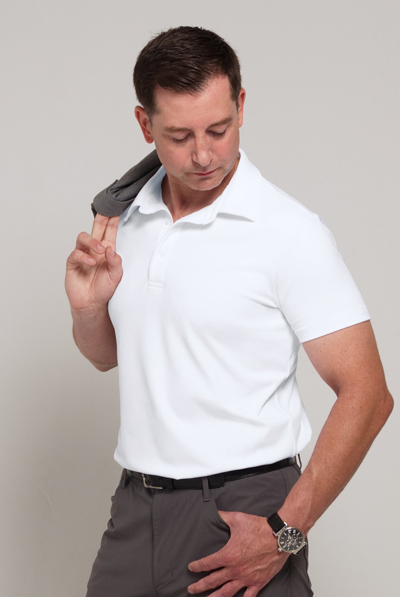 Three-quarter front view of a man wearing TARANIRVANA Aria Polo in Porcelain white, showcasing a sharp minimalist aesthetic in high-performance SpiroTex™ fabric with quick-dry, moisture-wicking, odor-resistant, and UPF 50+ sun protection.