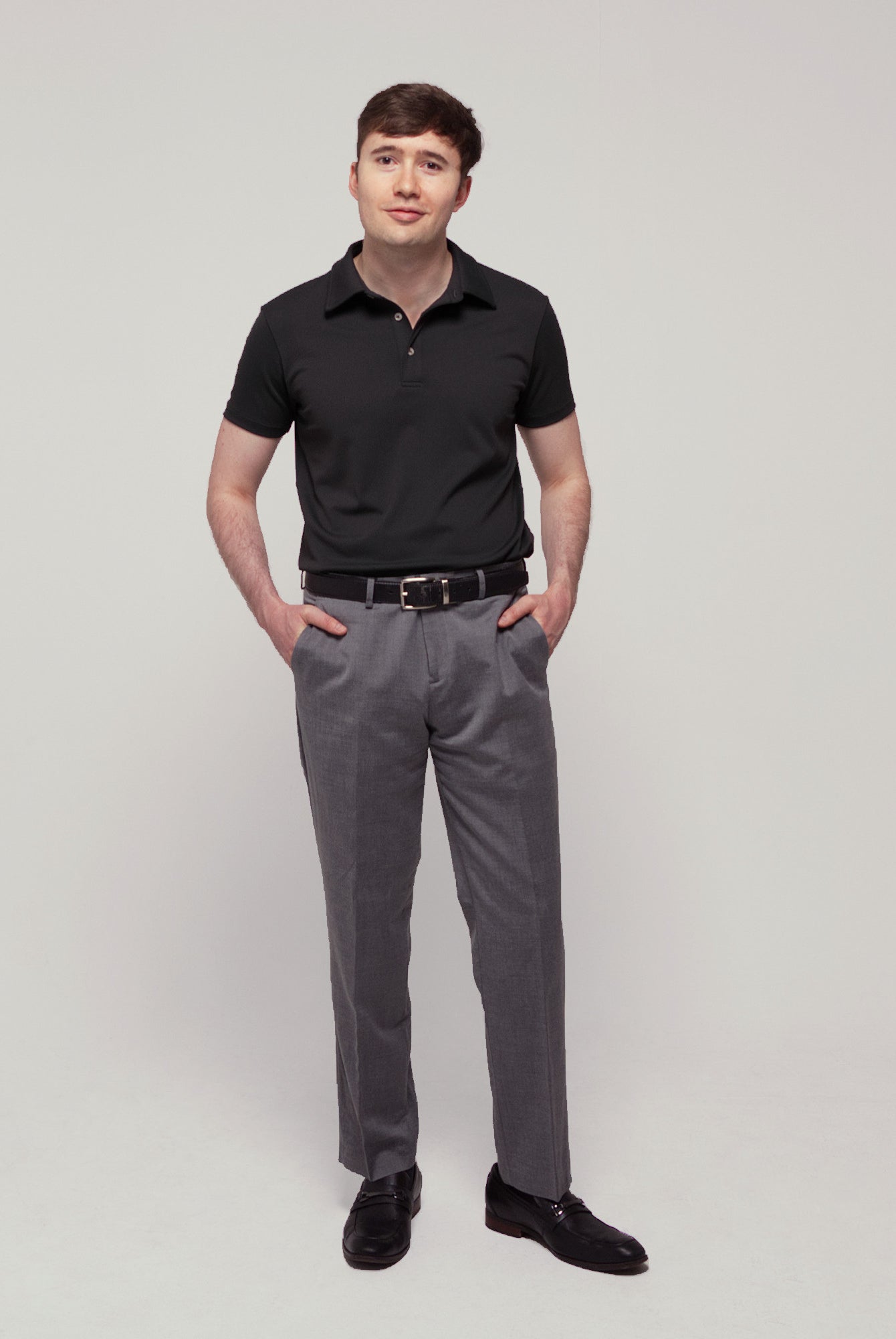 Front view of a man wearing TARANIRVANA Aria Polo in Phantom black, showcasing a sharp tailored business silhouette in high-performance SpiroTex™ fabric with quick-dry, moisture-wicking, odor-resistant, and UPF 50+ sun protection.
