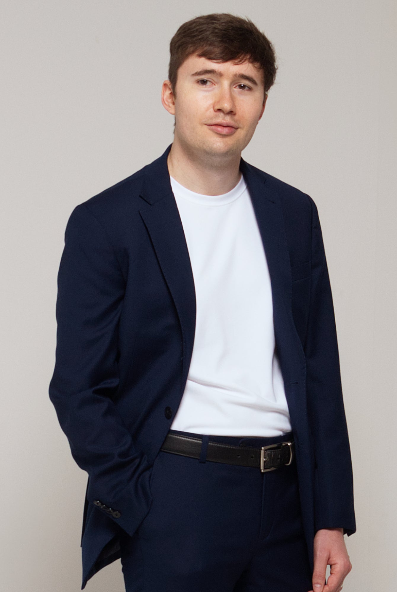 Three-quarter front view of a man wearing TARANIRVANA Essenza T-Shirt in Porcelain white, showcasing a sophisticated smart business silhouette in high-performance SpiroTex™ fabric with quick-dry, moisture-wicking, odor-resistant, and UPF 50+ sun protection.