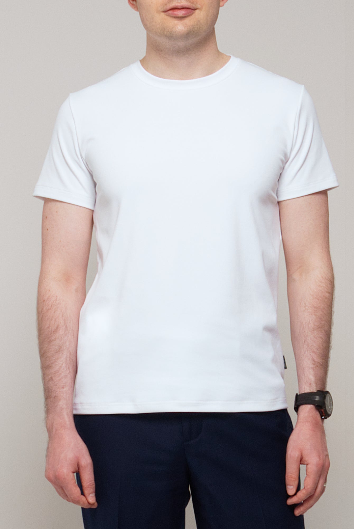 Front view of a man wearing TARANIRVANA Essenza T-Shirt in Porcelain white, showcasing a sophisticated smart business silhouette in high-performance SpiroTex™ fabric with quick-dry, moisture-wicking, odor-resistant, and UPF 50+ sun protection.
