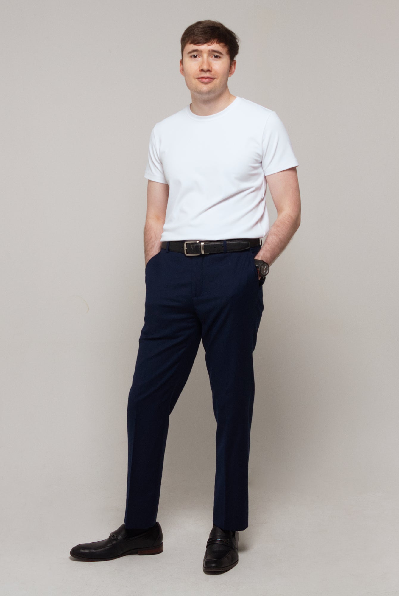 Full-length three-quarter view of a man wearing TARANIRVANA Essenza T-Shirt in Porcelain white, showcasing a refined smart casual silhouette in high-performance SpiroTex™ fabric with quick-dry, moisture-wicking, odor-resistant, and UPF 50+ sun protection.