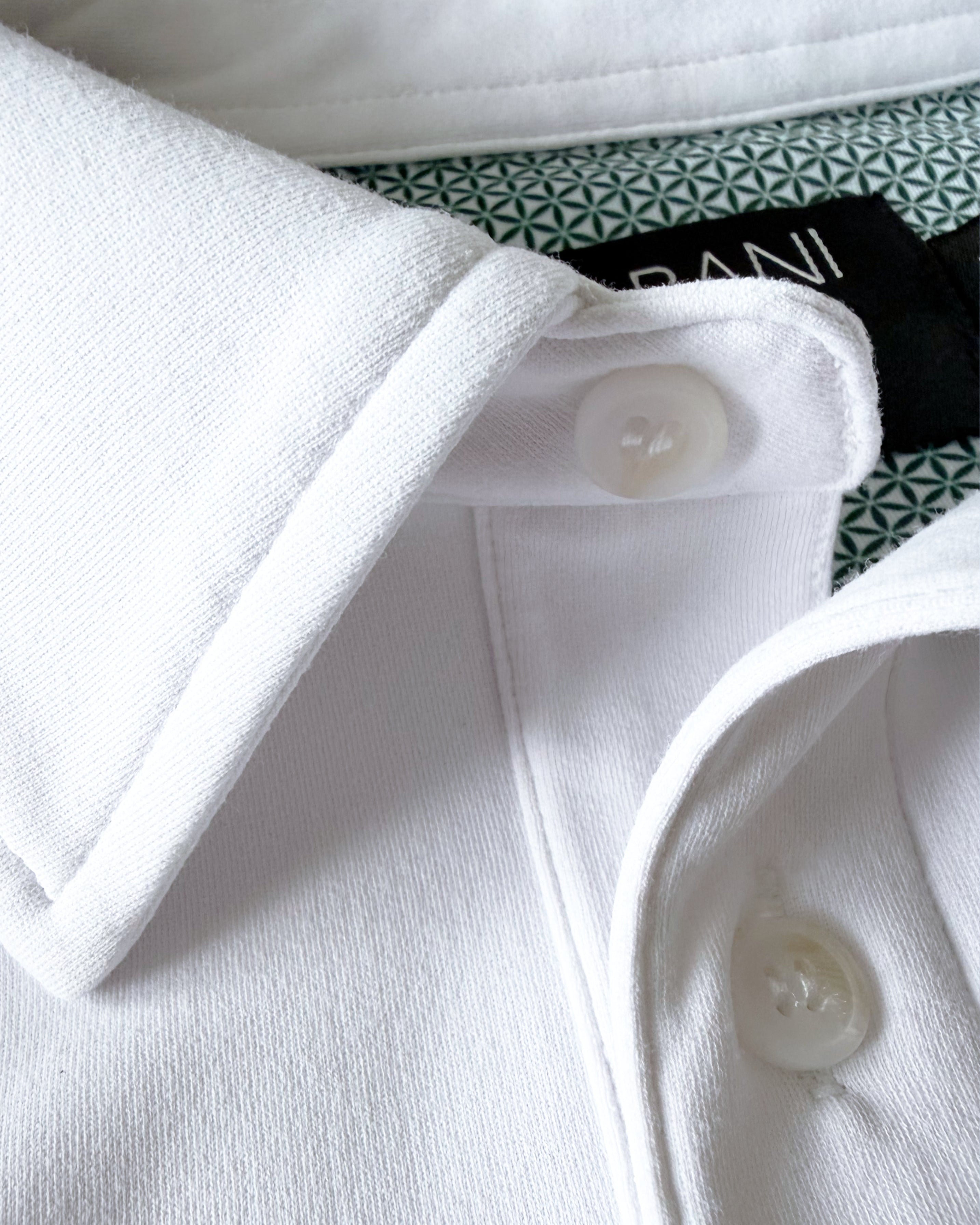 Close-up view of TARANIRVANA Porcelain white Polo shirt collar, highlighting the premium placket buttons, minimalist tailored collar, and high-performance SpiroTex™ fabric with quick-dry, moisture-wicking, odor-resistant, and UPF 50+ sun protection.