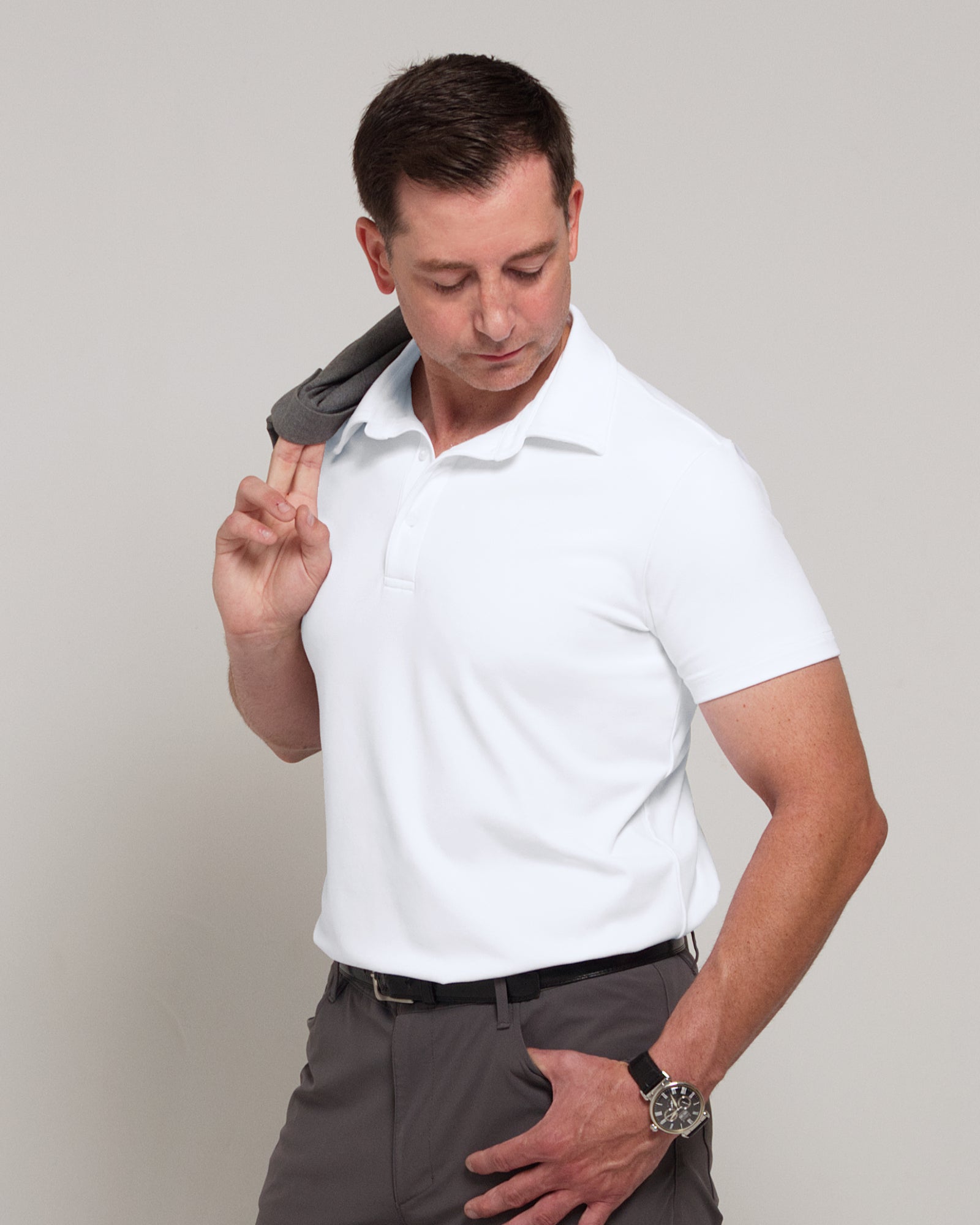 Three-quarter front view of a man wearing TARANIRVANA Aria Polo in Porcelain white, showcasing a sharp minimalist aesthetic in high-performance SpiroTex™ fabric with quick-dry, moisture-wicking, odor-resistant, and UPF 50+ sun protection.