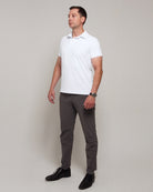 Full-length three-quarter view of a man wearing TARANIRVANA Aria Polo in Porcelain white, showcasing a sophisticated smart business silhouette in high-performance SpiroTex™ fabric with quick-dry, moisture-wicking, odor-resistant, and UPF 50+ sun protection.