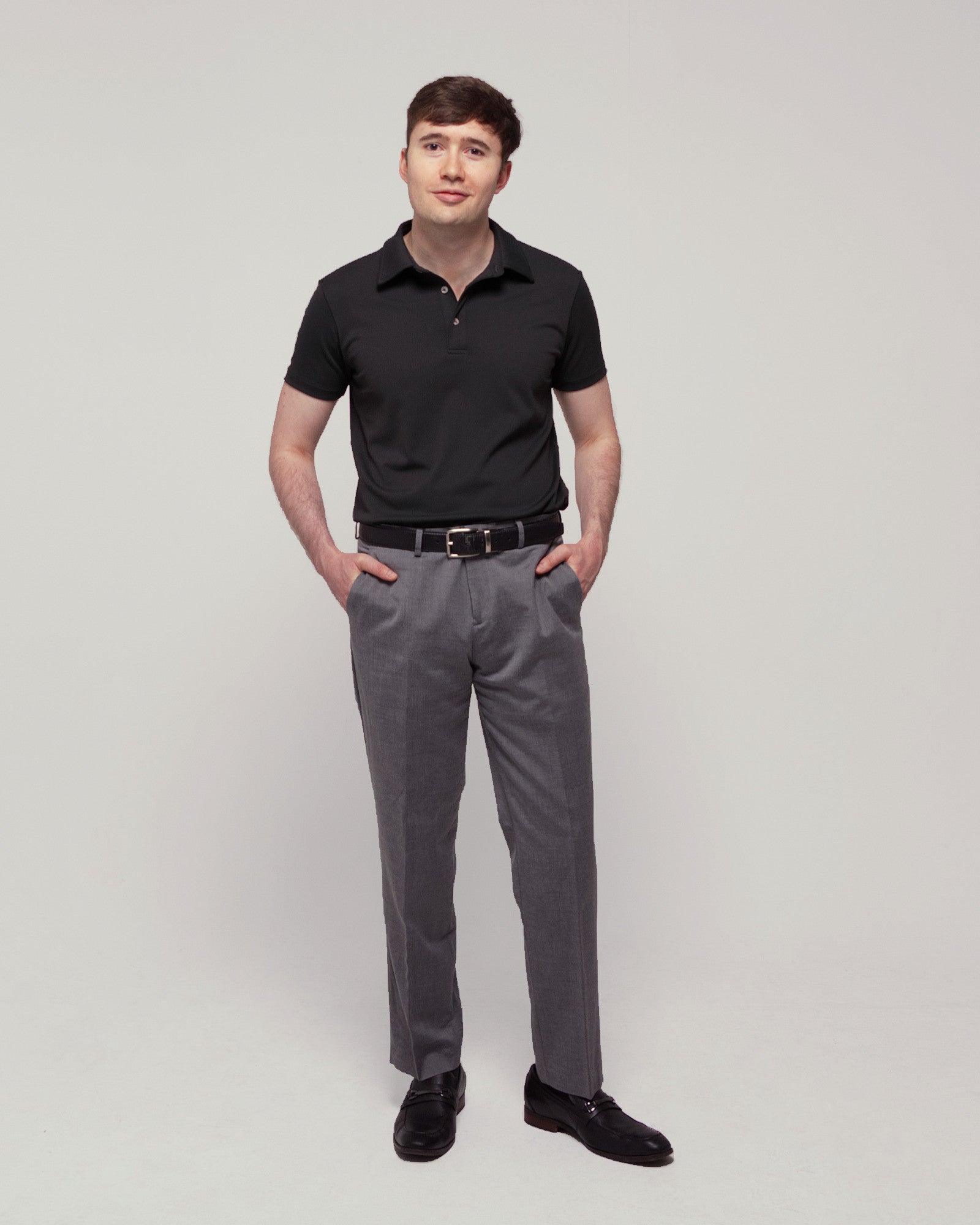 Front view of a man wearing TARANIRVANA Aria Polo in Phantom black, showcasing a sharp tailored business silhouette in high-performance SpiroTex™ fabric with quick-dry, moisture-wicking, odor-resistant, and UPF 50+ sun protection.
