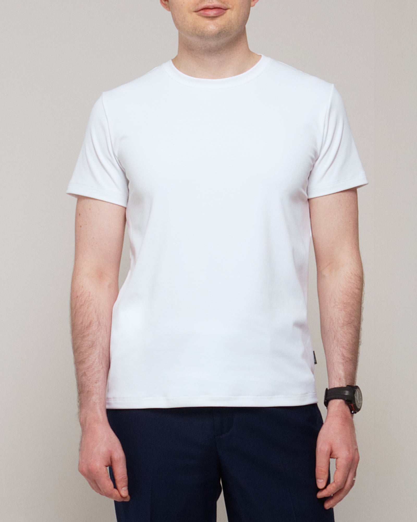 Front view of a man wearing TARANIRVANA Essenza T-Shirt in Porcelain white, showcasing a sophisticated smart business silhouette in high-performance SpiroTex™ fabric with quick-dry, moisture-wicking, odor-resistant, and UPF 50+ sun protection.