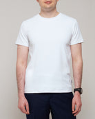 Front view of a man wearing TARANIRVANA Essenza T-Shirt in Porcelain white, showcasing a sophisticated smart business silhouette in high-performance SpiroTex™ fabric with quick-dry, moisture-wicking, odor-resistant, and UPF 50+ sun protection.