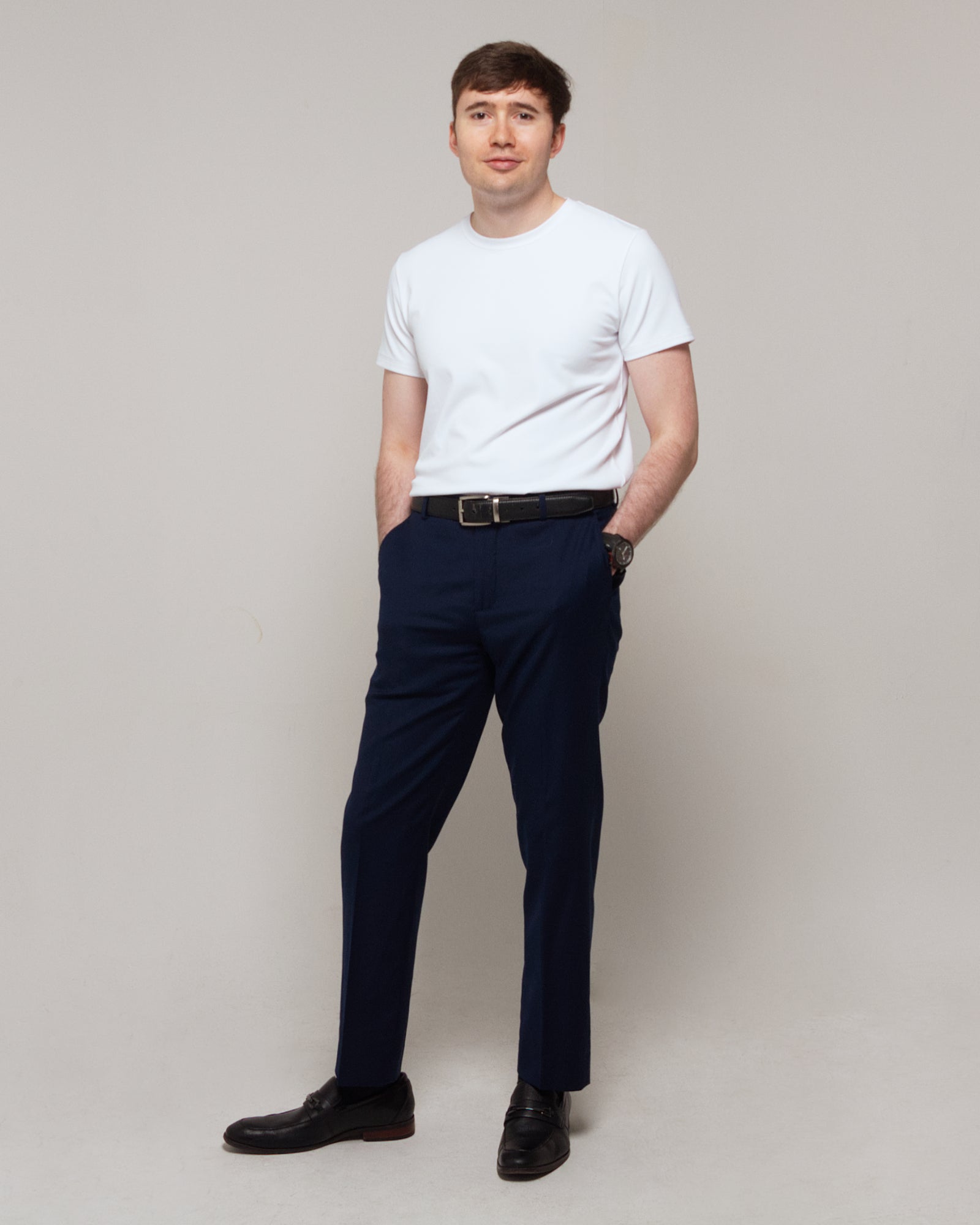 Full-length three-quarter view of a man wearing TARANIRVANA Essenza T-Shirt in Porcelain white, showcasing a refined smart casual silhouette in high-performance SpiroTex™ fabric with quick-dry, moisture-wicking, odor-resistant, and UPF 50+ sun protection.