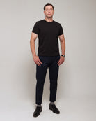 Front view of a man wearing TARANIRVANA Essenza T-Shirt in Phantom black, showcasing the classic crewneck and high-performance SpiroTex™ fabric with quick-dry, moisture-wicking, odor-resistant, and UPF 50+ sun protection.